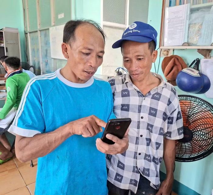 2 anh em ngư dân Nguyễn Thành Học (bên phải) và Nguyễn Thành Hỏi thực hiện yêu cầu nhập bến, khai báo sản lượng tại Cảng cá Quy Nhơn sáng 20-6. Ảnh: N.T