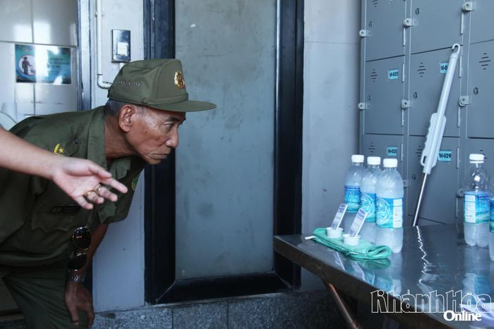 Một thành viên lực lượng bảo vệ an ninh trật tự ở cơ sở kiểm tra kết quả hiển thị que test nhanh.