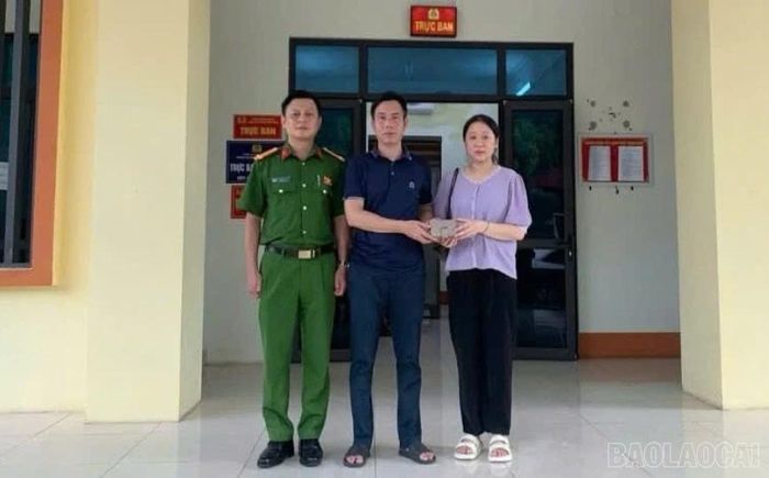Anh Trần Văn Cường trao trả toàn bộ tài sản bị đánh rơi cho chị Đỗ Thu Trang tại trụ sở Công an phường Cam Đường.
