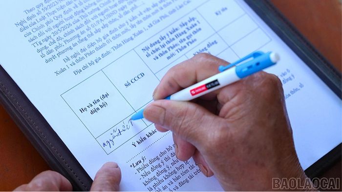 Người dân tham gia ký phiếu lấy ý kiến về phương án sắp xếp, sáp nhập thôn, tổ dân phố tại địa phương.