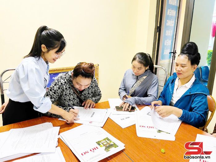 Cán bộ xã Lóng Phiêng hướng dẫn nhân dân hoàn thiện hồ sơ cho con đi học tại Trường Nội trú liên cấp Tiểu học và THCS xã Lóng Phiêng.