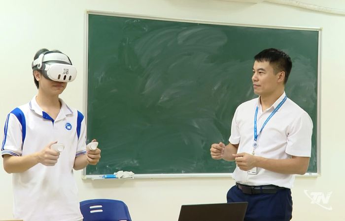 Giảng viên Trường Đại học Công nghệ thông tin và Truyền thông hướng dẫn sinh viên trải nghiệm ứng dụng công nghệ thực tế ảo mô phỏng xưởng lắp ráp ô tô.