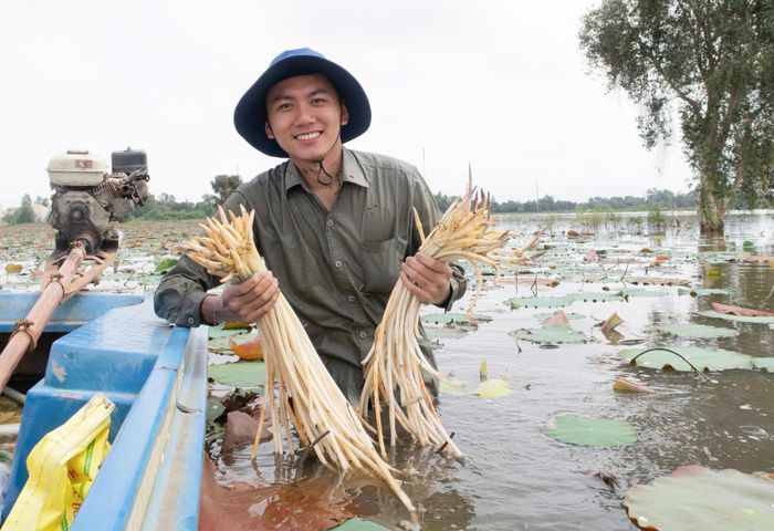 YouTuber Đinh Võ Hoài Phương trong video trải nghiệm nhổ ngó sen mùa nước nổi ở miền Tây. Ảnh: FBNV.