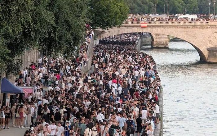 Những người tham dự lễ hội tập trung bên bờ sông Seine ở Paris trong điều kiện nhiệt độ cao. Ảnh: Luc Auffret/Anadolu/Getty