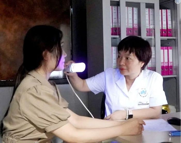 Bác sĩ đang khám những tổn thương trên da cho bệnh nhân.