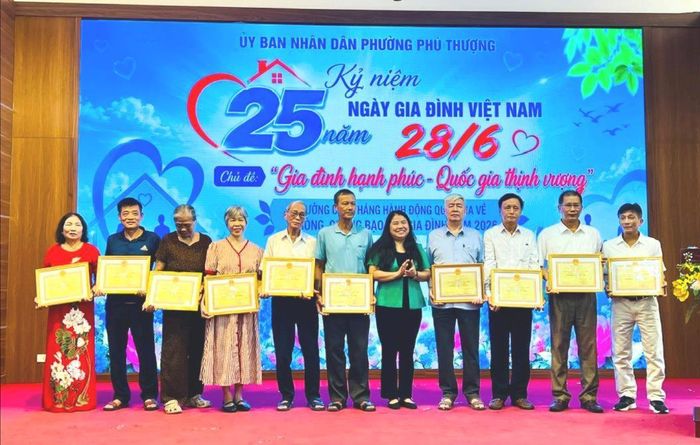 Chủ tịch Ủy ban MTTQ Việt Nam phường Phú Thượng Trương Tú Uyên trao khen thưởng cho các gia đình văn hóa tiêu biểu. Ảnh: Tuệ Lâm