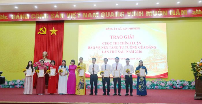 Chủ tịch Ủy ban MTTQ Việt Nam xã Tây Phương Nguyễn Hữu Hùng và Chủ nhiệm Ủy ban kiểm tra Đảng ủy xã Tây Phương Khuất Thanh Huyền trao giải Nhì cho các tác giả. Ảnh: Công Phương