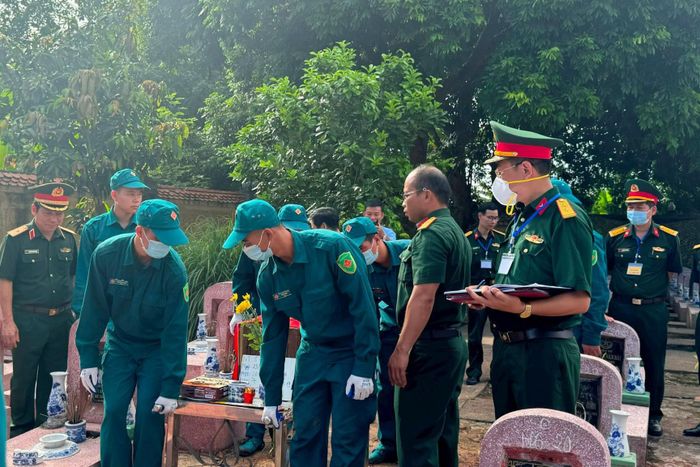 Trang trọng thực hiện quy trình khai quật, đưa hài cốt liệt sĩ chưa xác định danh tính về khu vực lấy mẫu sinh phẩm. Ảnh: Mai Hoa