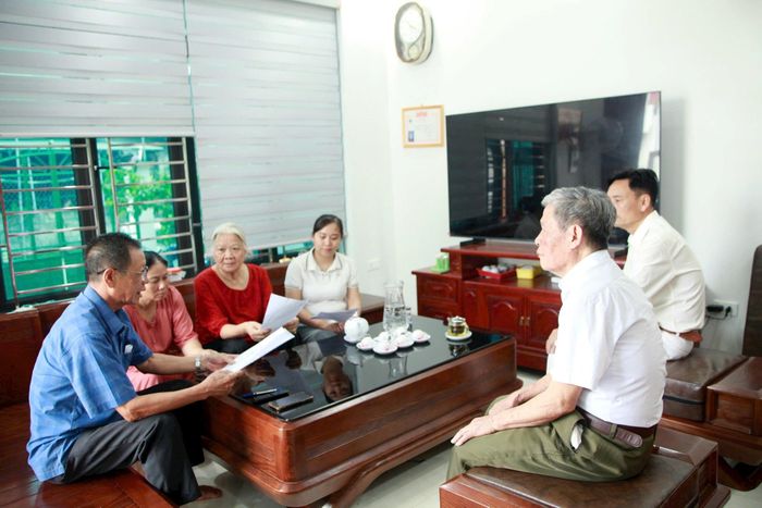 Các cán bộ thôn An Bình đến từng nhà lấy ý kiến người dân. Ảnh: Hồng Nhung