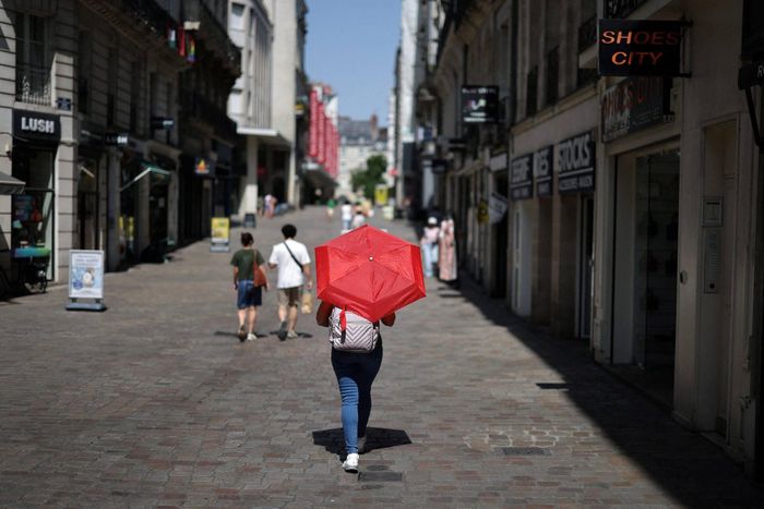  Một phụ nữ đi bộ trên đường phố Nantes trong lúc nhiệt độ tăng cao do đợt nắng nóng ảnh hưởng đến nhiều khu vực nước Pháp, ngày 22/6. Ảnh: Reuters. 
