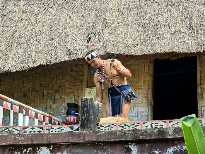 Già làng đứng trước nhà Rông thông báo về buổi lễ