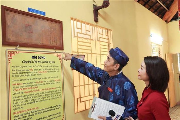 Ông Đồng Tấn Lợi, Thành viên Ban Quý tế đình Mỹ Hòa giới thiệu bản Sắc phong cổ được mật tàng từ năm 1852 đến nay. Ảnh: Hữu Duyên - TTXVN