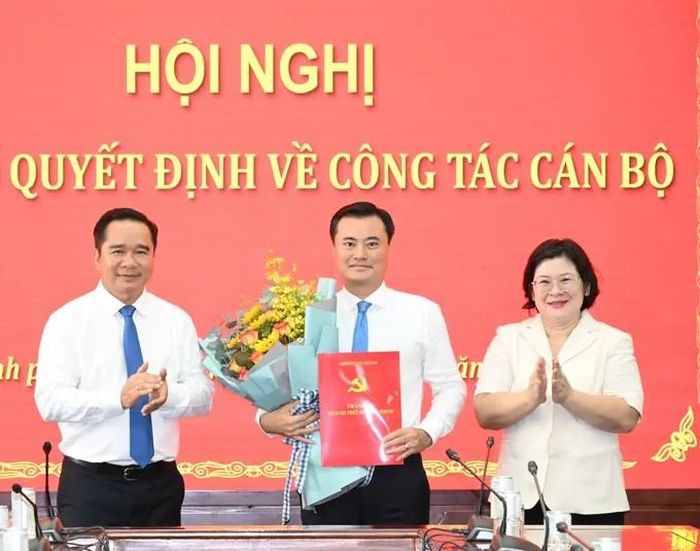 Đồng chí Nguyễn Văn Được và đồng chí Văn Thị Bạch Tuyết trao quyết định, tặng hoa chúc mừng đồng chí Bùi Xuân Cường