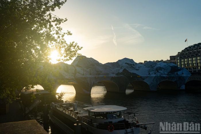Nhìn từ xa, cây cầu cổ nhất Paris như biến mất dưới lớp "đá" khổng lồ. Đây là một trong những tác phẩm nghệ thuật công cộng quy mô lớn nhất mà JR từng thực hiện tại thủ đô nước Pháp.