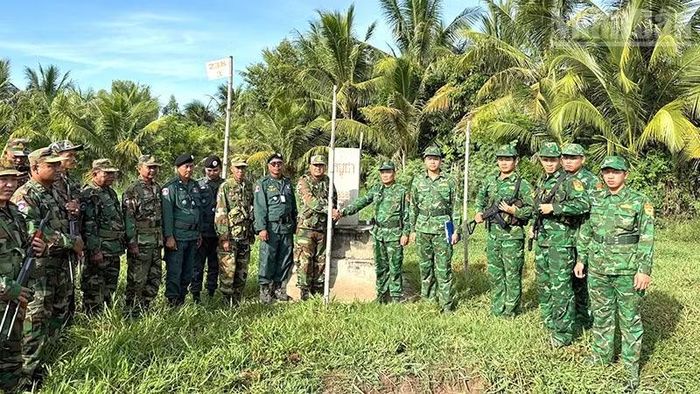 Cán bộ, chiến sĩ 2 bên chụp hình lưu niệm tại cột mốc trong đợt tuần tra song phương.