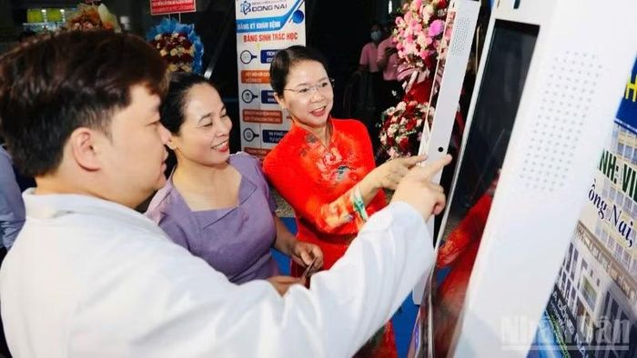 Giám đốc Sở Y tế Đồng Nai Đỗ Thị Nguyên (giữa), cùng đại biểu trải nghiệm hệ thống nhận diện sinh trắc học ở Bệnh viện đa khoa Đồng Nai.