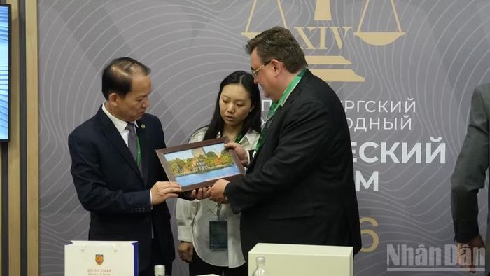 Bộ trưởng Hoàng Thanh Tùng tặng quà Bộ trưởng Tư pháp Nga Konstantin Chuychenko. (Ảnh: THANH THỂ)
