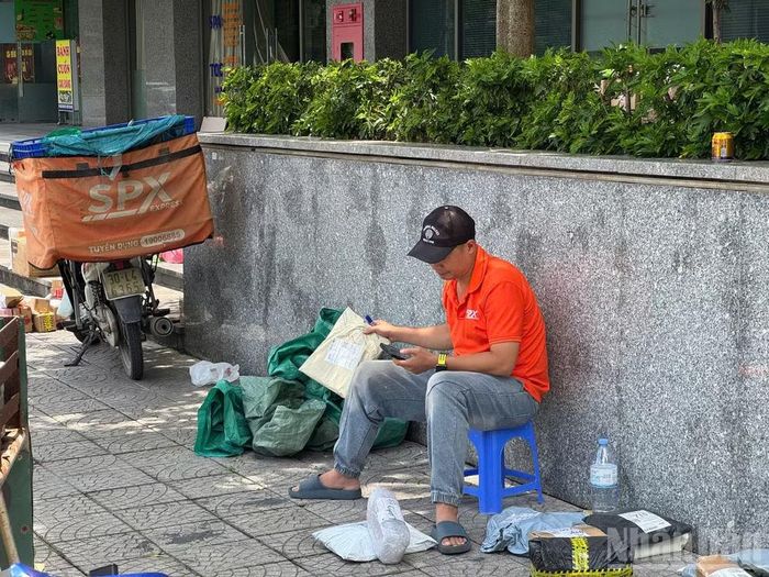 Anh Thắng cùng với rất nhiều đơn hàng dưới cái nắng hơn 40 độ C. (Ảnh: Anh Duy)