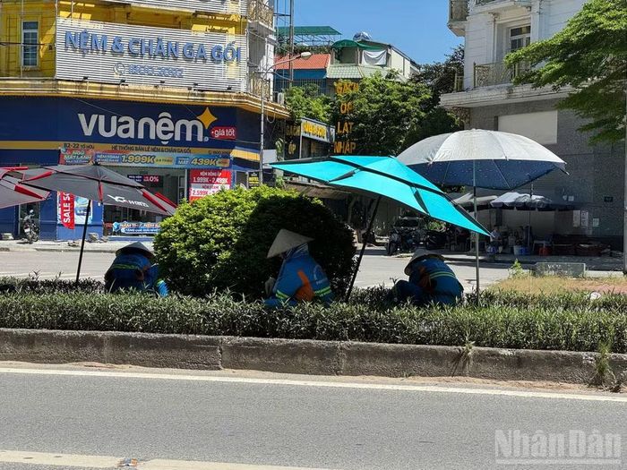 Công nhân môi trường phải cầm theo ô và mặc cho mình chiếc áo có quạt làm mát cho cơ thể.