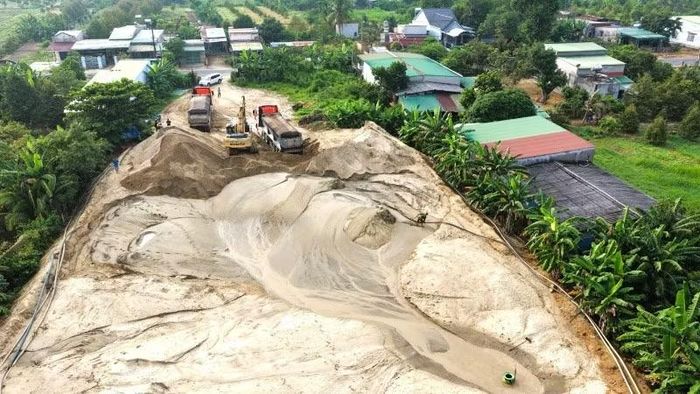 Máy móc xúc cát lên phương tiện để đi tiêu thụ.