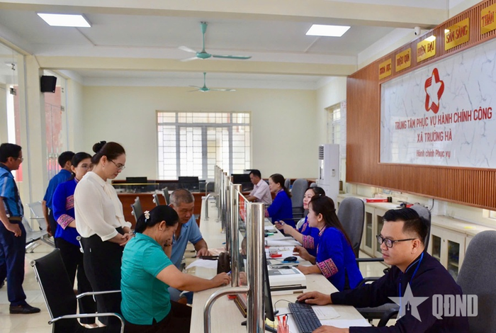 Chủ tịch UBND xã Trường Hà (tỉnh Cao Bằng) Linh Thanh Tuyền (mặc áo trắng) trò chuyện cùng người dân tại Trung tâm Phục vụ hành chính công xã. Ảnh: CHIẾN THẮNG