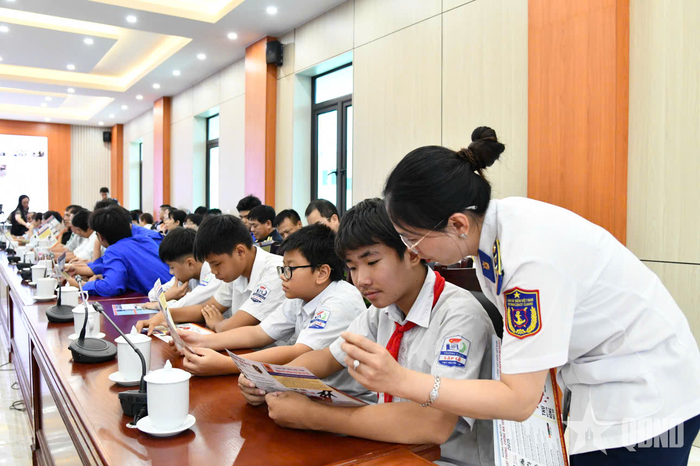 Tuyên truyền và phát tờ rơi phổ biến pháp luật cho các em học sinh. 