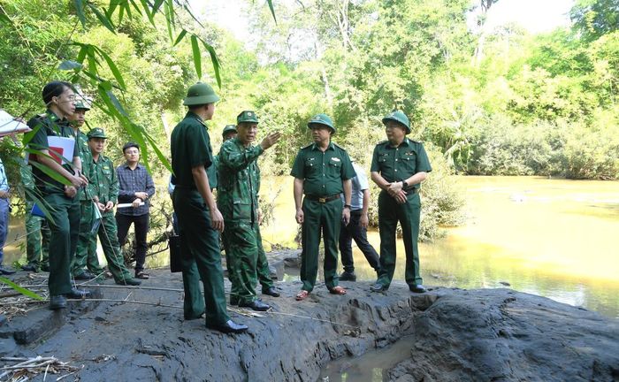 Đoàn công tác trực tiếp kiểm tra các vị trí có nguy cơ sạt lở, ảnh hưởng đến đường biên giới trên sông, suối. Ảnh: Ngọc Lân