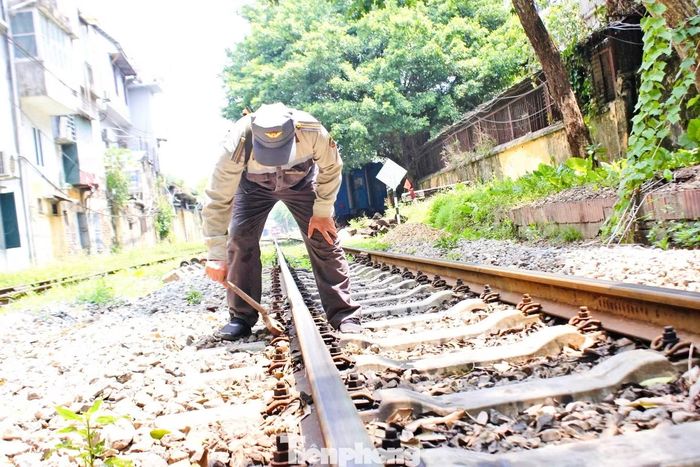 Trưa 24/6, ông Hưng kiểm tra hệ thống liên kết trên đường ray đoạn qua khu vực phố Khâm Thiên. Công việc của người tuần đường là quan sát từng thanh ray, từng mối nối, bu lông, tà vẹt để phát hiện hư hỏng nhỏ nhất có thể ảnh hưởng tới an toàn chạy tàu.