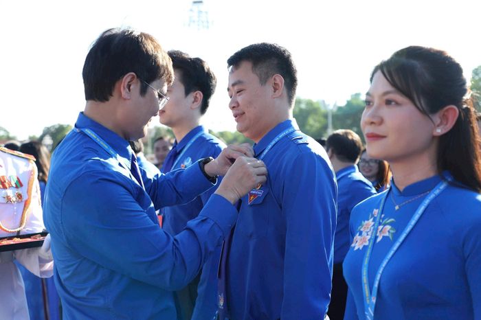 Trao huy hiệu Bác Hồ cho các đại biểu.