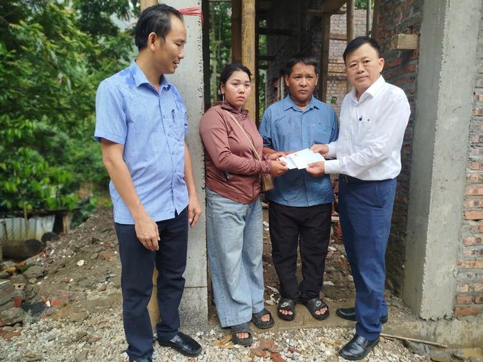 Ông Ma Thế Luận (ngoài cùng bên phải), Phó Vụ trưởng Vụ Tuyên truyền công tác dân tộc, tôn giáo thăm, tặng quà gia đình bà Lò Thị Nguyệt. Ảnh: HBH