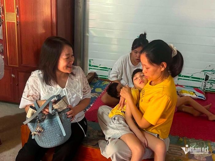 Đại diện Báo VietNamNet động viên gia đình chị Mai Thị Tươi có hai con gái song sinh bị bại não