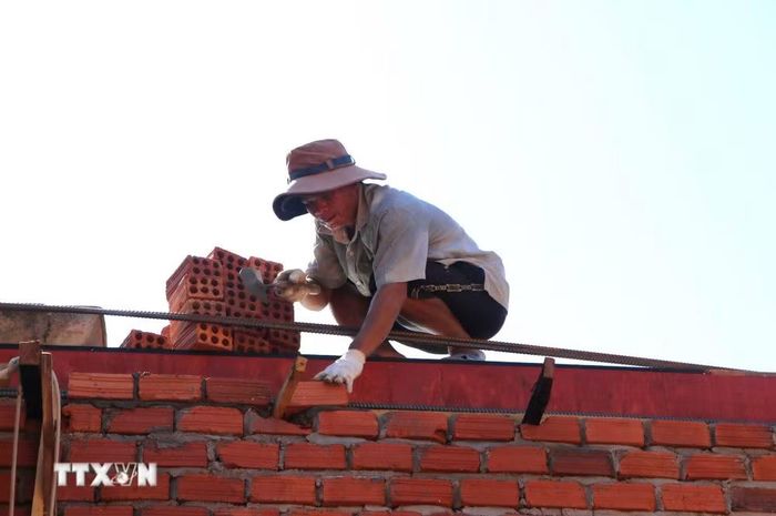 Tranh thủ thời tiết thuận lợi, thợ xây nỗ lực xây dựng để hoàn thành nhà theo kế hoạch. (Ảnh: Đinh Hương/ TTXVN)