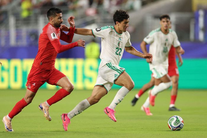 Tiền vệ Algeria Ibrahim Maza (số 22) đi bóng trong sự đeo bám sát sao của tiền vệ Jordan Noor Alrawabdeh. Ảnh: AFP/TTXVN (Ảnh không cho phép bên thứ ba khai thác, chia sẻ lại)