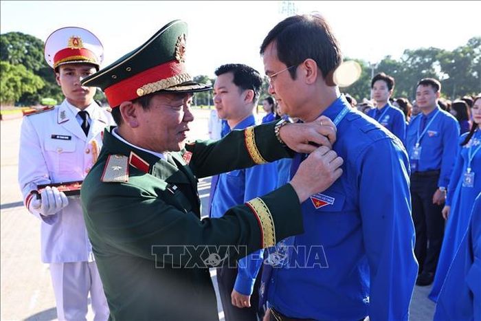 Trao huy hiệu Bác Hồ cho các đại biểu.