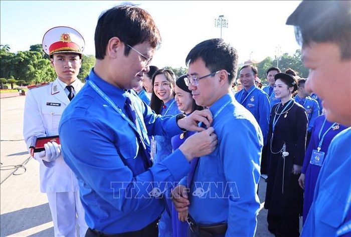 Trao huy hiệu Bác Hồ cho các đại biểu.