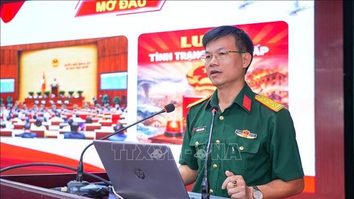 Báo cáo viên, Thượng tá, Thạc sĩ Nguyễn Văn Tuyền, Phó Chủ nhiệm Chính trị Trường Quân sự Quân khu 7, giới thiệu các nội dung trọng tâm của Luật Tình trạng khẩn cấp và cơ chế ứng phó các tình huống khẩn cấp trong tình hình mới.