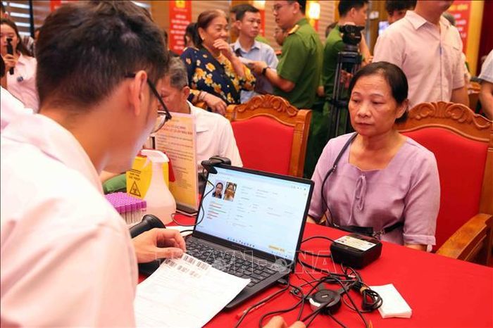 Thân nhân Liệt sĩ chưa xác định thông tin trên toàn quốc làm thủ tục lấy mẫu sinh phẩm ADN tại buổi lễ. Ảnh: Phạm Kiên/TTXVN