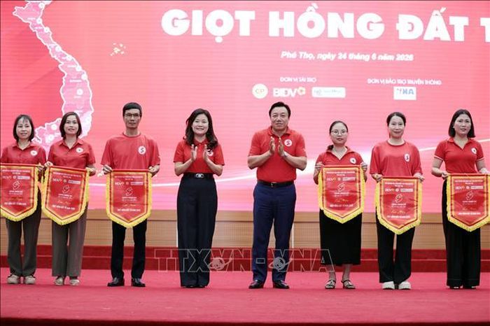 Phó Chủ tịch UBND tỉnh Phú Thọ Nguyễn Huy Ngọc trao cờ lưu niệm cho các đơn vị tham gia chương trình.