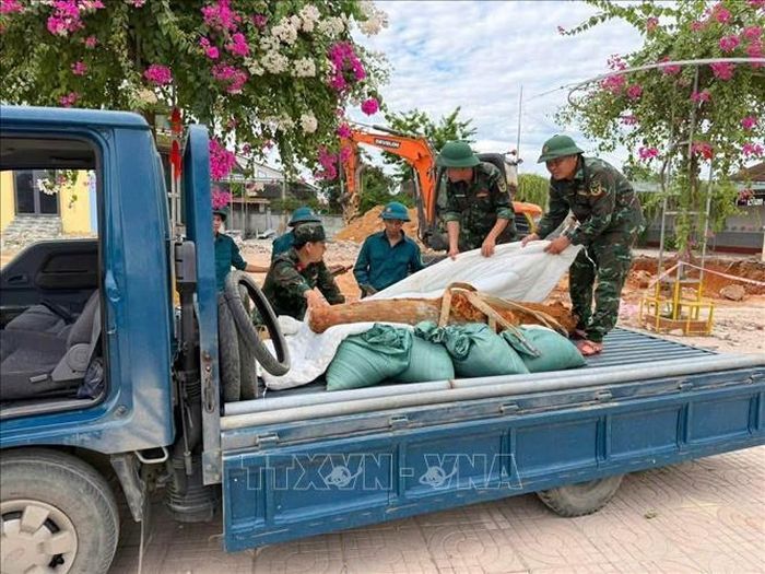 Lực lượng chức năng tiến hành di dời quả bom nến nơi hủy nổ. Ảnh: TTXVN phát