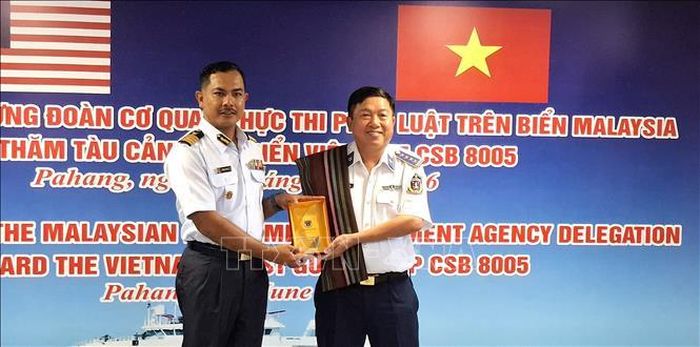 Đại tá Trần Nguyên Lai, Phó tư lệnh, Tham mưu trưởng Bộ tư lệnh Vùng Cảnh sát biển 4, tặng quà lưu niệm cho ông Mohd Marmizi bin Md Nor, Phó Giám đốc Cơ quan thực thi hàng hải Malaysia (MMEA) bang Pahang. Ảnh: Bùi Hoàn/PV TTXVN tại Malaysia
