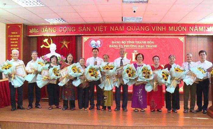 Lãnh đạo phường Hạc Thành trao Huy hiệu Đảng và tặng hoa chúc mừng các đảng viên 60 năm tuổi Đảng trở lên.