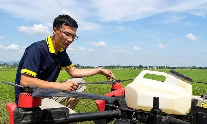 Anh Nông Văn Dinh bên chiếc Drone phun thuốc ở cánh đồng mẫu lớn. Ảnh: Đình Giang
