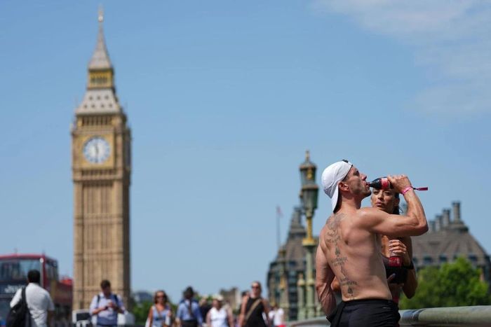 Một người đàn ông đang uống nước trên cầu Westminster ở London. Ảnh: Al jazeera