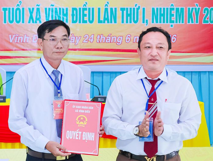 Phó Chủ tịch UBND xã Vĩnh Điều Nguyễn Văn Hướng trao quyết định hợp nhất cho Hội Người cao tuổi xã Vĩnh Điều.