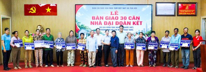 Đại diện các hộ dân nhận bảng tượng trưng bàn giao nhà Đại đoàn kết.