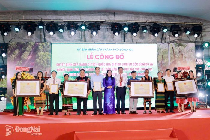 Đồng chí Dương Minh Dũng, Ủy viên Ban Thường vụ Thành ủy, Trưởng ban Tuyên giáo và Dân vận Thành ủy và đồng chí Lê Thị Ngọc Loan, Thành ủy viên, Giám đốc Sở Văn hóa, Thể thao và Du lịch trao Quyết định và Giấy chứng nhận Danh mục di sản văn hóa phi vật thể quốc gia: Tập quán giã gạo chày tay của người S’tiêng, người Mnông cho đại diện của 8 xã (Bom Bo, Long Hà, Tân Hưng, Tân Tiến, Bù Đăng, Thọ Sơn, Đak Nhau và Bù Gia Mập). Ảnh: Minh Hạnh