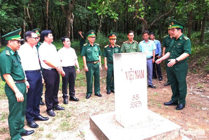Đại tá Nguyễn Anh Đức (bìa phải) giới thiệu với đại biểu về mốc giới do Đồn Biên phòng Tân Thành quản lý, bảo vệ nằm trên địa bàn xã Tân Tiến. Ảnh: Nguyệt Hà