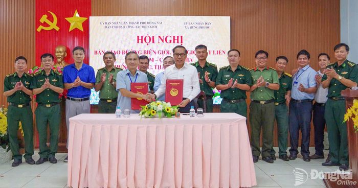 Đại diện Ban Chỉ đạo công tác biên giới thành phố Đồng Nai và xã Hưng Phước thực hiện nhiệm vụ bàn giao. Ảnh: Nguyễn Cường