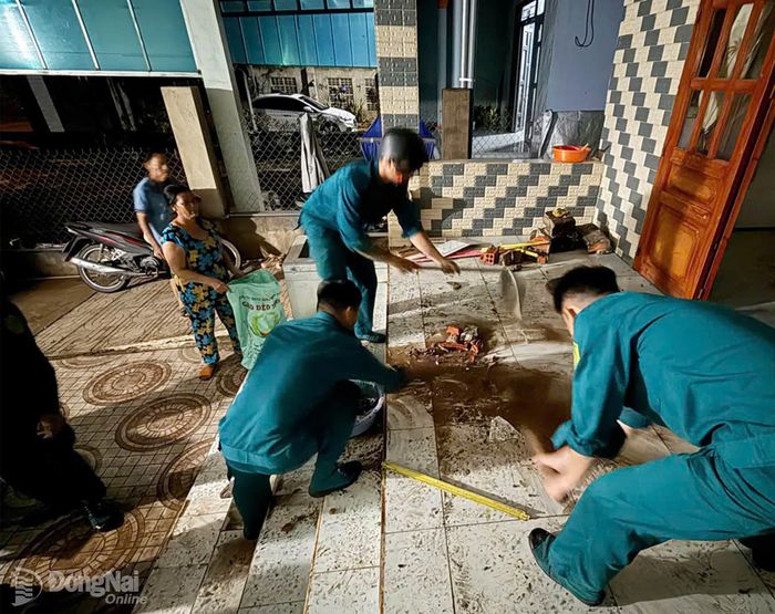 Lực lượng chức năng xã Bàu Hàm hỗ trợ các hộ dân dọn đẹp nhà cửa, khắc phục hậu quả thiên tai. Ảnh: CTV