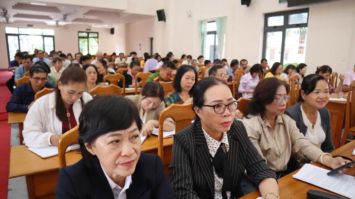 Các đại biểu tham dự hội nghị theo dõi, nghiên cứu báo cáo để thảo luận, đóng góp ý kiến